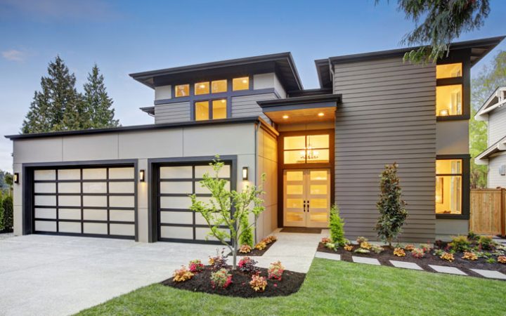 a modern custom home with a driveway, garage, and front yard&nbsp;landscaping